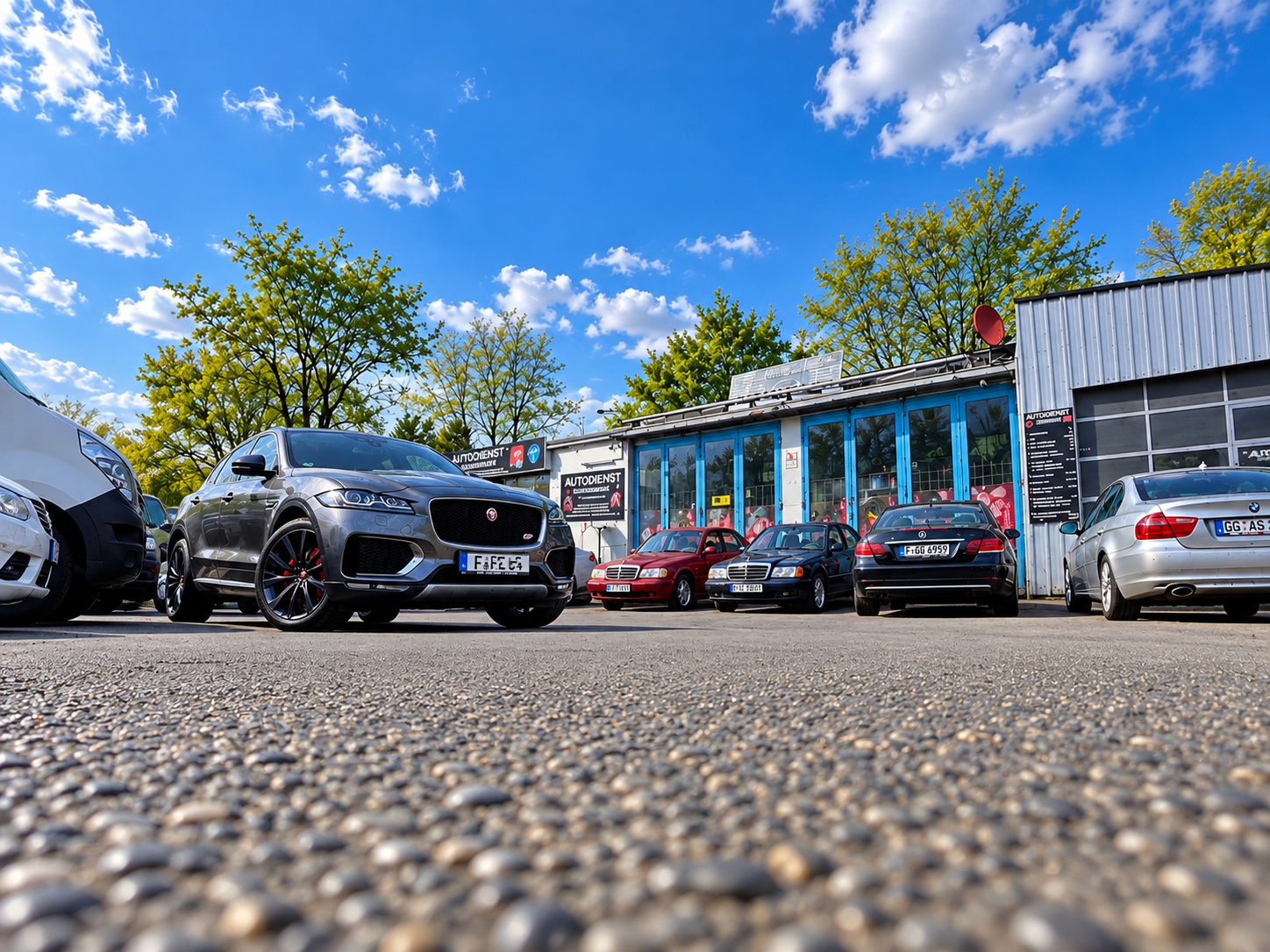 Außenansicht von Autodienst Schwanheim mit Fahrzeugen vor der Werkstatt